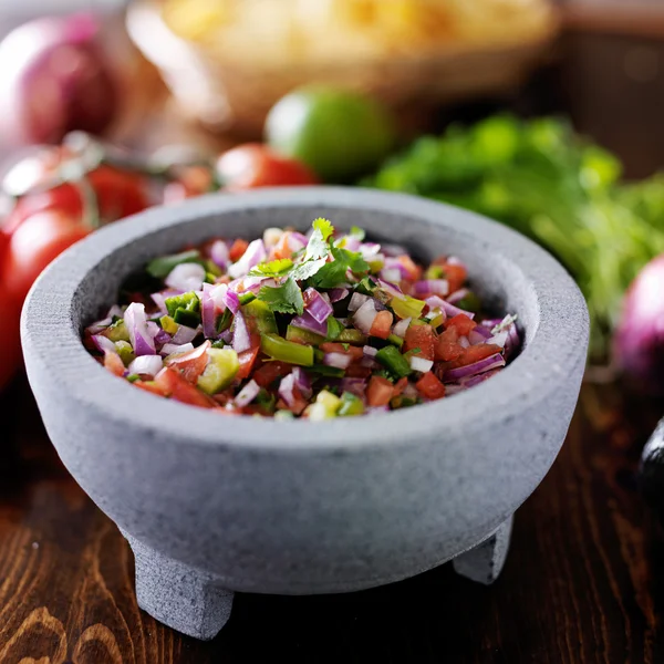 Pico de gallo salsa in Fican stone molcajete — стоковое фото