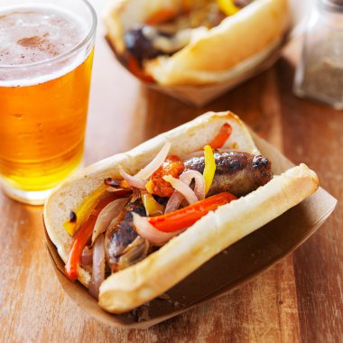 grilled bratwurst covered in onions and peppers clipart