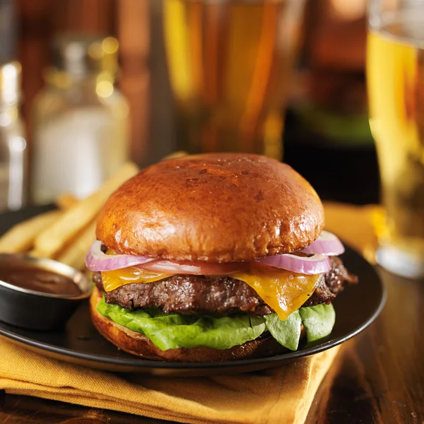 Cheeseburger e batatas fritas no prato — Fotografia de Stock