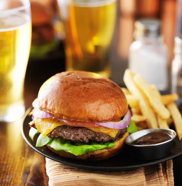 Cheeseburger en frietjes op plaat — Stockfoto