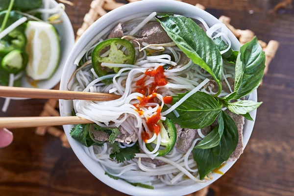 Pho vietnamita con carne de res comido con palillos — Foto de Stock