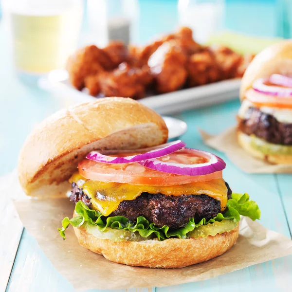 Cheeseburgers met vleugels en bier — Stockfoto