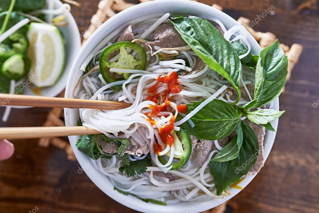 Vietnamese pho with beef eaten with chopsticks Stock Photo by ©resnick