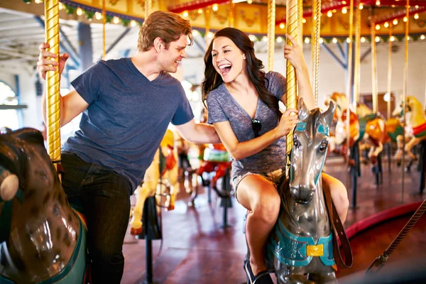 Romantic couple riding carousel — Stock Photo, Image