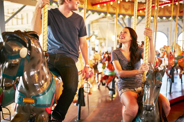 Couple riding merry go round — Stock Photo, Image