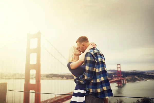 Ouple beijos na frente do portão dourado — Fotografia de Stock