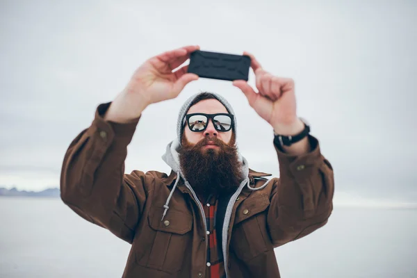 Vousatý bederní s selfie v sůl byty s retro tón — Stock fotografie