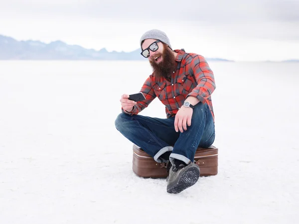 Γενειάδα hipster με έξυπνο τηλέφωνο και κοστούμι υπόθεση το Αλυκές ψάχνει για οδηγίες — Φωτογραφία Αρχείου