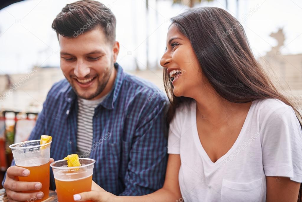 happy hispanic couple drinking beer 