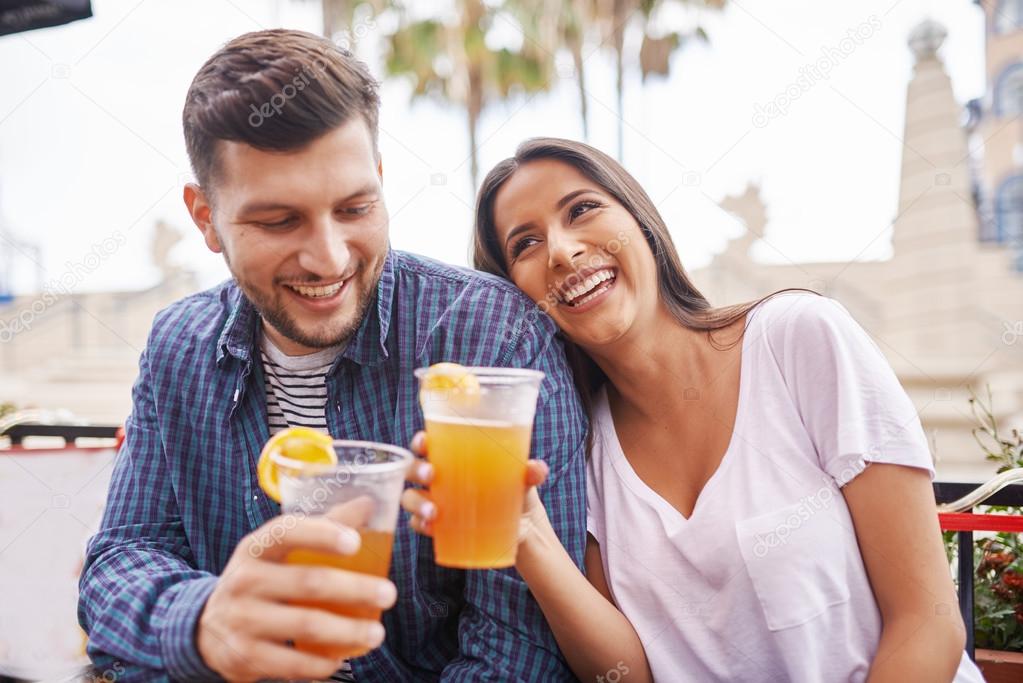 romantic hispanic couple drinking beer 