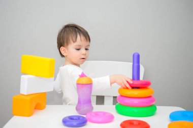 Evde renkli küplerle oynayan sevimli küçük bir çocuk.,