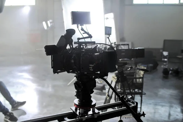 Profesional video studio.Behind-the-scenes of a video shooting.Behind the shooting production silhouette of camera and equipment in studio.Selective focus.