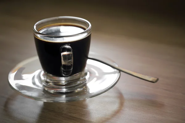 Черный кофе с ложкой на дереве — стоковое фото