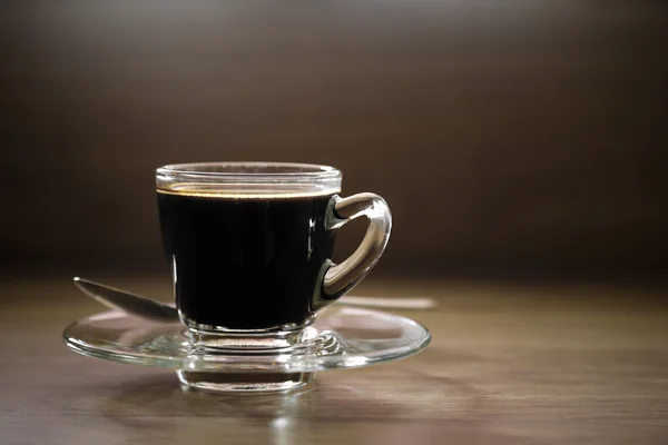 Xícara de café preto e colher em madeira — Fotografia de Stock