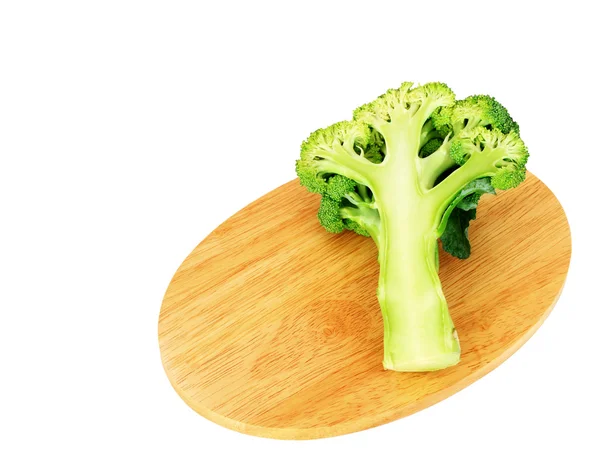 Broccoli on wooden chopping board over white — Stock Photo, Image