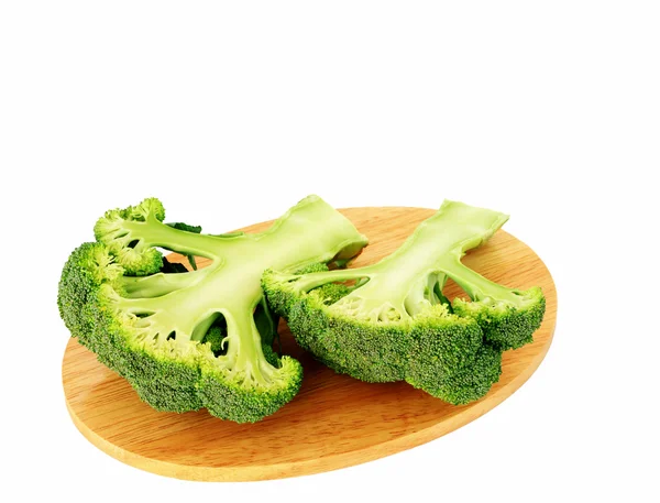 Broccoli on wooden chopping board over white — Stock Photo, Image