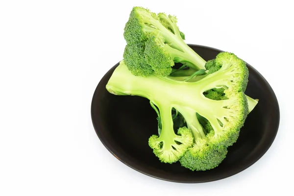 Half of broccoli on black dish over white. — Stock Photo, Image
