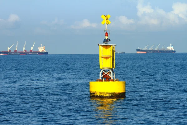 Boa di navigazione gialla galleggiante sul mare blu — Foto Stock