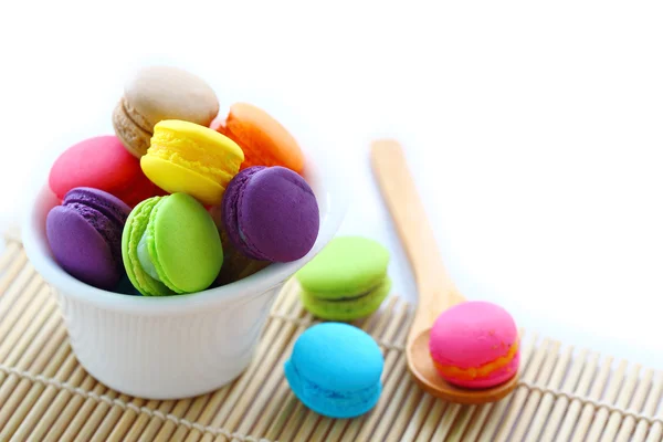 Bunte Macarons in weißer Tasse mit Löffel auf weißer — Stockfoto