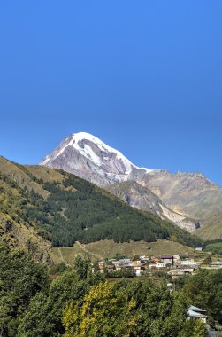 Gergeti village, Georgia yakınındaki Mount Kazbek ve Holy Trinity Kilisesi (Tsminda Sameba) görünümü