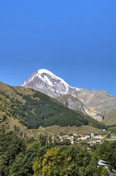 Vista do Monte Kazbek e da Igreja da Santíssima Trindade (Tsminda Sameba) perto da aldeia de Gergeti, Geórgia — Fotografia de Stock