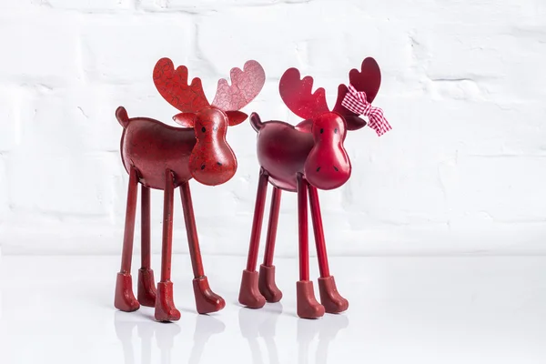 Red reindeer on white brick wall — Stock Photo, Image
