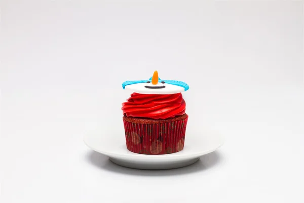 Christmas cupcake with butter cream icing on the saucer. Snowman — Stock Photo, Image