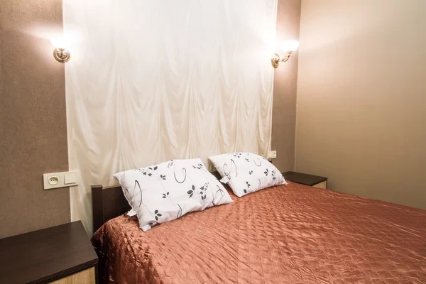 Cama con una manta marrón y almohadas, primer plano interior de la habitación . —  Fotos de Stock