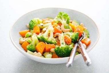 Sebzeli salata kasesi brokoli, fırında balkabağı, avokado ve fındık. Sağlıklı vejetaryen yemekleri