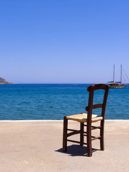 Old wooden chair near the sea - Crete, Greece — Stock Photo, Image