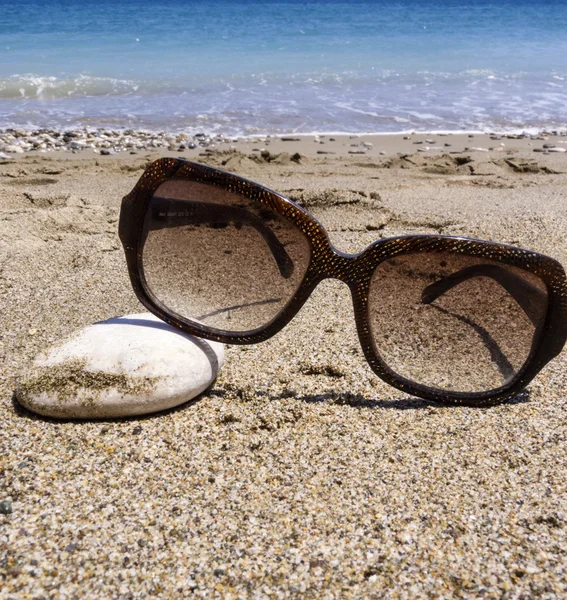 Sunglasses lying on rocky beach — Stock Photo, Image