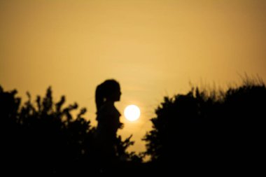 Sounion 'da gün batımında güneşi izleyen bir kız silueti. Attica, Yunanistan.