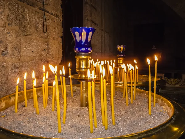 Velas ardientes dentro de la capilla apedreada — Foto de Stock