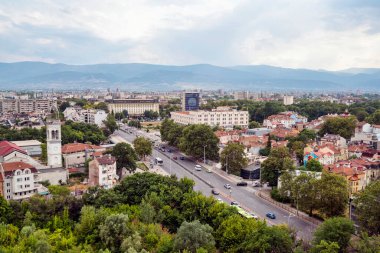 Filibe, Bulgaristan - 7 Ağustos 2025: Uzakta bir kilise kulesi, merkez bulvar, çatılar ve Rodop Dağları yer alıyor..