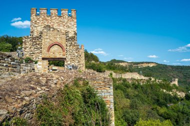 Bulgaristan 'ın Veliko Tarnovo kentindeki Çarevets Kalesi' ne taş döşeli ortaçağ girişi, kale duvarları ve arka planda kulesi bulunuyor..