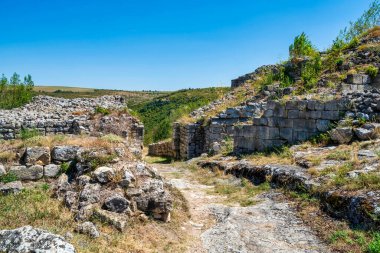 Bulgaristan 'daki ortaçağ Cherven Kalesi' nin antik taş kalıntıları ve savunma duvarları derin bir nehir geçidine tünemiş ve engebeli uçurumlar ve yaz bitkileriyle çevrili..