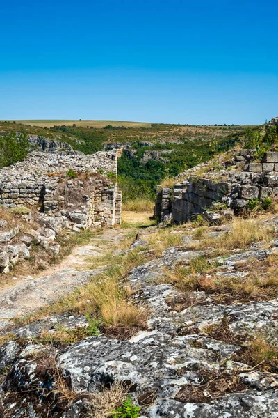 Bulgaristan 'daki ortaçağ Cherven Kalesi' nin antik taş kalıntıları ve savunma duvarları derin bir nehir geçidine tünemiş ve engebeli uçurumlar ve yaz bitkileriyle çevrili..