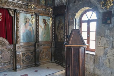 Ortodoks ikonostaz zengin ahşap oymalar ve gün ışığıyla aydınlanan dini simgelerle Basarbovo Manastırı 'ndaki kaya yontulmuş kilisede..