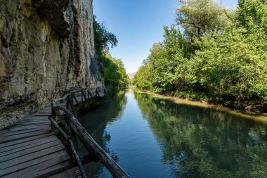 Sakin Rusenski Lom nehrinin üzerindeki kireçtaşı kayalıklara bağlı tahta kaldırımlar kuzey İspanya 'daki sık ormanlarla çevrili..