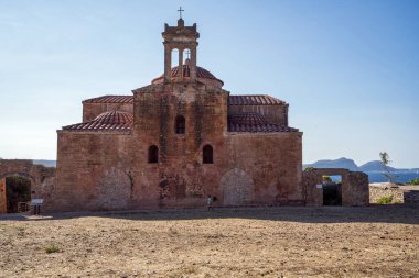 Pylos, Yunanistan - 20 Ağustos 2025: Pylos, Yunanistan 'daki Pylos Kalesi (Niokastro) içinde bulunan Dönüşüm Tarihi Kilisesi. Fotoğraf, kendine özgü kubbeleri, çan kulesi ve yıpranmış dış yüzeyi olan eski taş yapıyı gösteriyor..