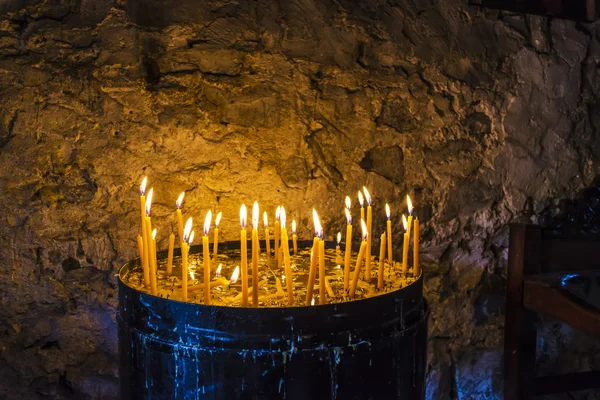 Горящие свечи внутри каменного монастыря — стоковое фото