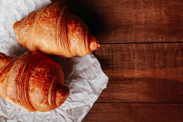 Croissant Dalam Bungkusan Kertas Kerajinan Dengan Latar Belakang Meja Coklat — Stok Foto
