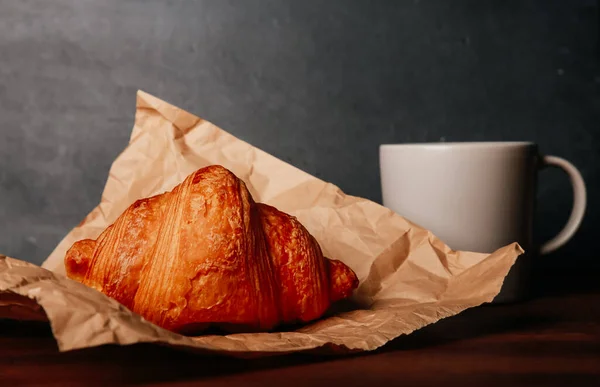 Croissant Segar Dipanggang Atas Kertas Kerajinan Cangkir Kopi Atas Meja — Stok Foto