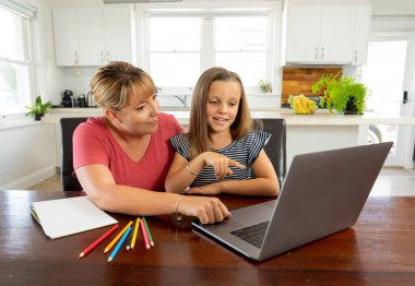 Anne, kendi başına ya da karantinada kızına evde çalışmasında yardım ediyor. Coronavirus 'un ikinci dalga konsepti nedeniyle eğitim, evde eğitim, uzaktan eğitim ve okulun kapanması.