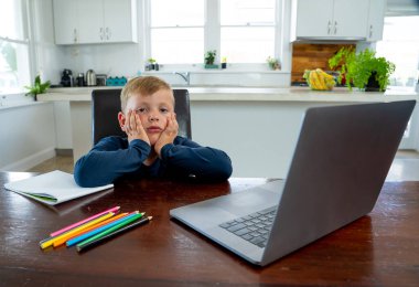 Çevrimiçi eğitim derslerinde sanal ders izleyen üzgün okul çocuğu evde kendini soyutlanmış ve sıkılmış hissediyor. COVID-19 ikinci dalga, karantina, okul kapatma ve uzaktan öğrenme kavramı.