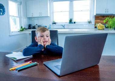 Çevrimiçi eğitim derslerinde sanal ders izleyen üzgün okul çocuğu evde kendini soyutlanmış ve sıkılmış hissediyor. COVID-19 ikinci dalga, karantina, okul kapatma ve uzaktan öğrenme kavramı.