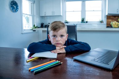 Çevrimiçi eğitim derslerinde sanal ders izleyen üzgün okul çocuğu evde kendini soyutlanmış ve sıkılmış hissediyor. COVID-19 ikinci dalga, karantina, okul kapatma ve uzaktan öğrenme kavramı.