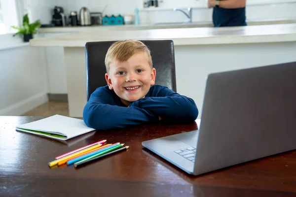 Happy Schoolboy on laptop watching online lesson learning remotely at home in self-isolation. Education, Quarantines and Schools reopening or shutting down in-person learning due to COVID-19 Pandemic.