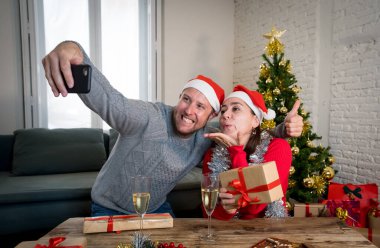 Cep telefonlu mutlu çift video görüşmesi Sanal Noel 'i ve yeni yılı kutluyorlar. COVID-19 nedeniyle kış tatillerinde sanal kutlamalar, sosyal mesafeler.