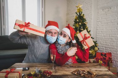 Kameralı mutlu çiftin görüntüsü, sanal Noel 'i ve yeni yıl partisini evde kilitli bir şekilde kutlayan video görüntüsü. COVID-19 sosyal uzaklık, kişisel izolasyon ve online kutlamalar.